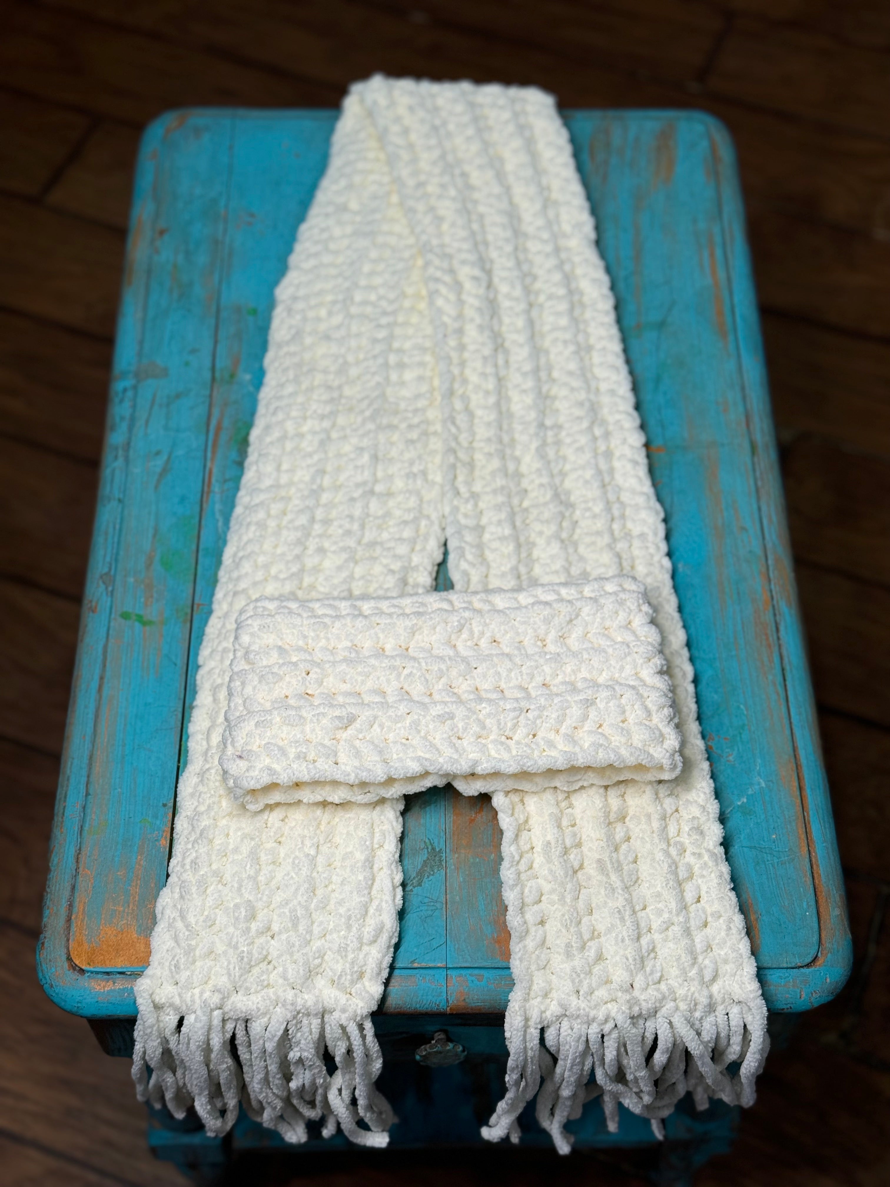 Soft White Chenille Scarf folded on a turquoise rustic table.