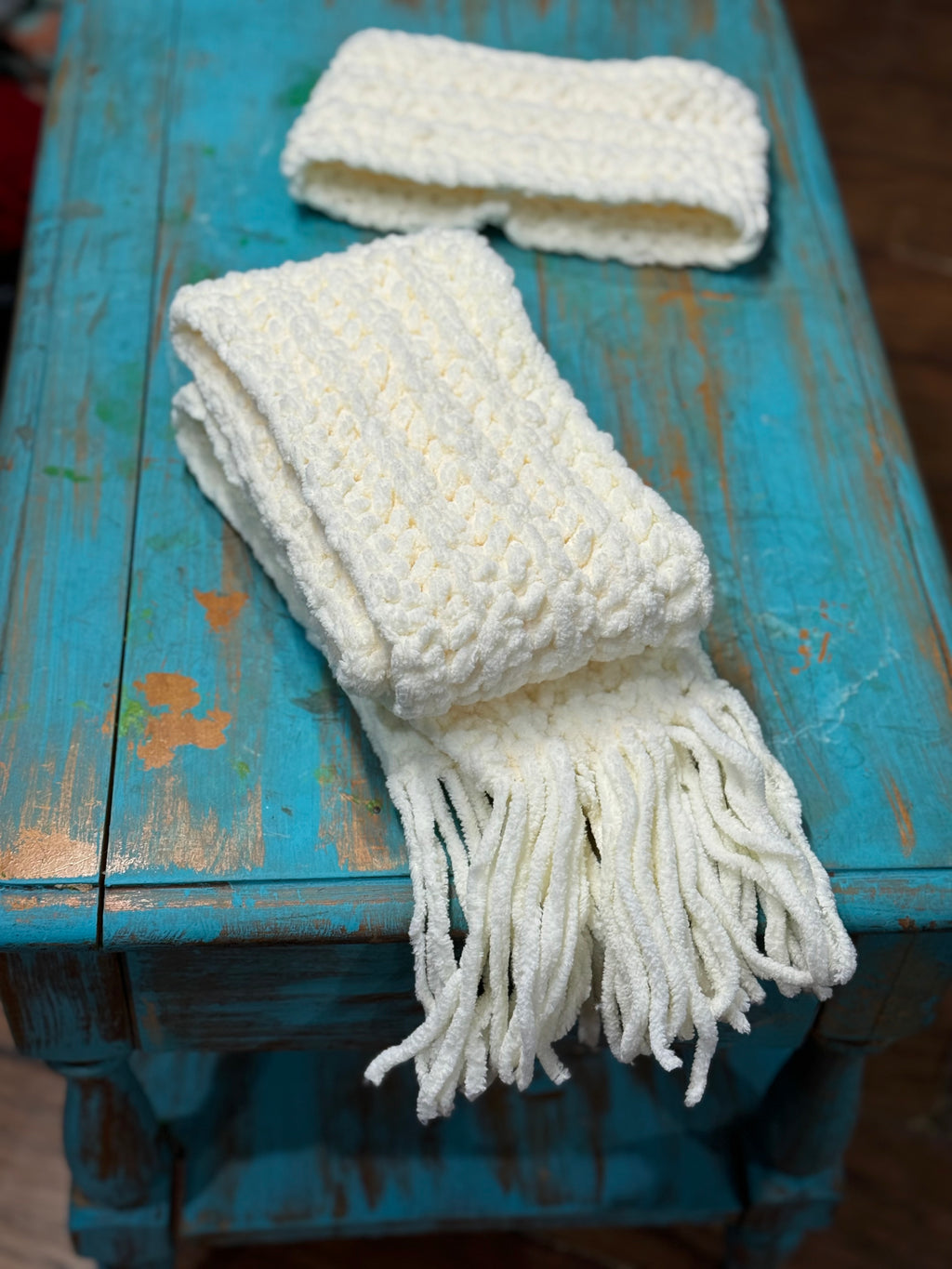 White Chenille Scarf on a Rustic Turquoise Table.