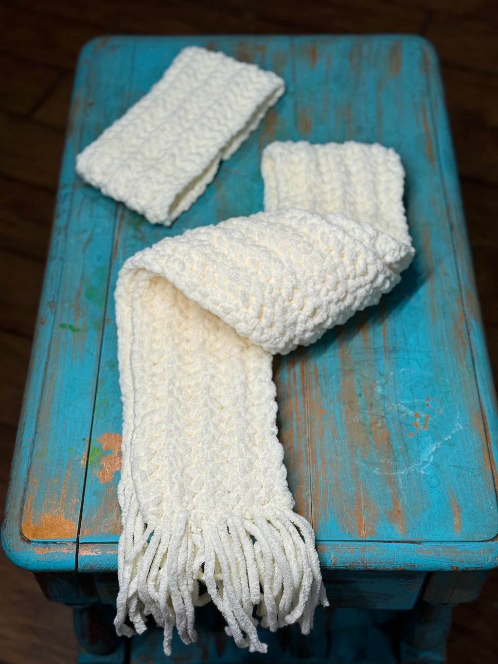 White Chenille Scarf Twisted and layed on a Turquoise Rustic Table.